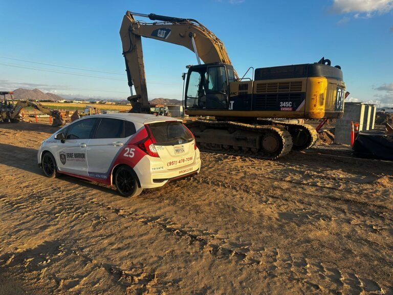 Brave Warrior patrol car parked beside an excavator at a construction site.